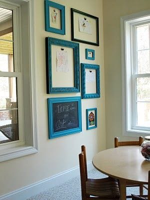 32 Mirror Decorating Ideas - Transform Home With Mirrors 10 Stylish wall decor featuring an artistic arrangement of turquoise-framed mirrors and artwork on a cream wall, enhancing the living room's ambiance.