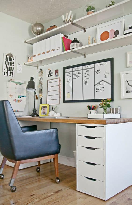 Home office with a sleek 60-inch wood desk, ergonomic black chair, compact storage unit with five white drawers, and open shelving for decor and organization.