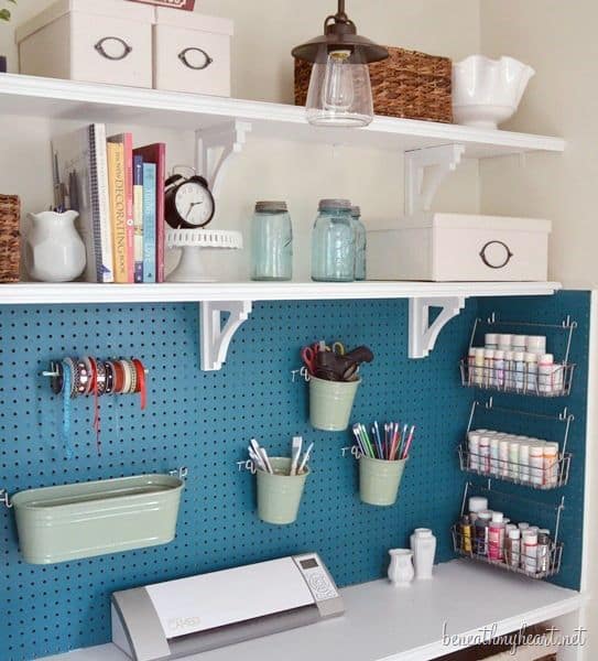 Minimalist small office setup with open shelving, teal pegboard for organizing supplies, and a clean aesthetic for productivity.