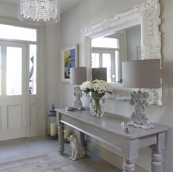 32 Mirror Decorating Ideas - Transform Home With Mirrors 14 Elegant entrance hallway with a light grey console table, two neutral table lamps, and a large ornate white mirror enhancing the airy feel.
