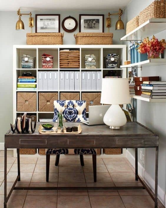Modern home office with a 60-inch steel desk and upholstered chair on tiled flooring. Features organized storage, natural light, and decorative elements.