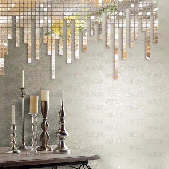32 Mirror Decorating Ideas - Transform Home With Mirrors 6 Mirrored decor enhances depth and light in a modern interior, featuring cascading pieces and silver candle holders against a beige wall.
