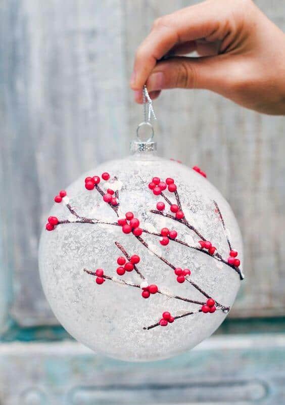 Christmas ornament with a spherical glass shape, 4 inches in diameter, featuring a frosted white finish and intricate red berry designs.