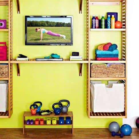 36 Home Gym Ideas - Layouts For Your Perfect Workout Spot 11 Home gym with a vibrant lime green wall, wooden shelving, colorful dumbbells, yoga mats, and warm hardwood flooring for an energizing workout space.