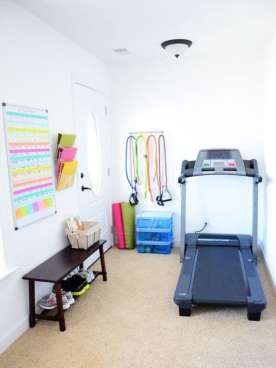 36 Home Gym Ideas - Layouts For Your Perfect Workout Spot 19 Home gym features a treadmill, black wooden bench, and organized resistance bands in a cozy 8x10 space with natural light.