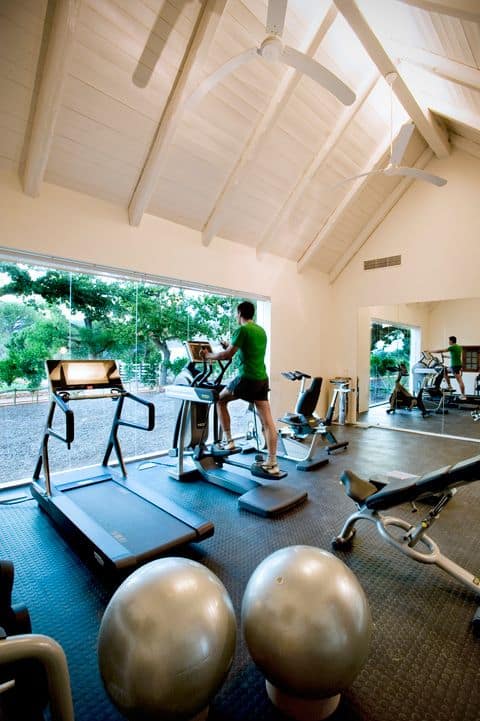 36 Home Gym Ideas - Layouts For Your Perfect Workout Spot 7 Spacious home gym with treadmills, elliptical, and strength training equipment. High ceilings and large windows enhance natural light.