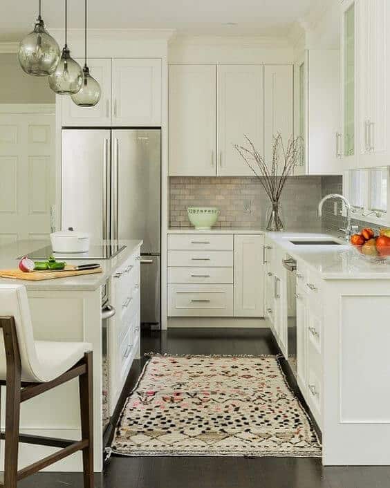 Sleek small kitchen with white cabinetry, stainless steel appliances, and a central granite island. Bright, inviting space with clever storage solutions.