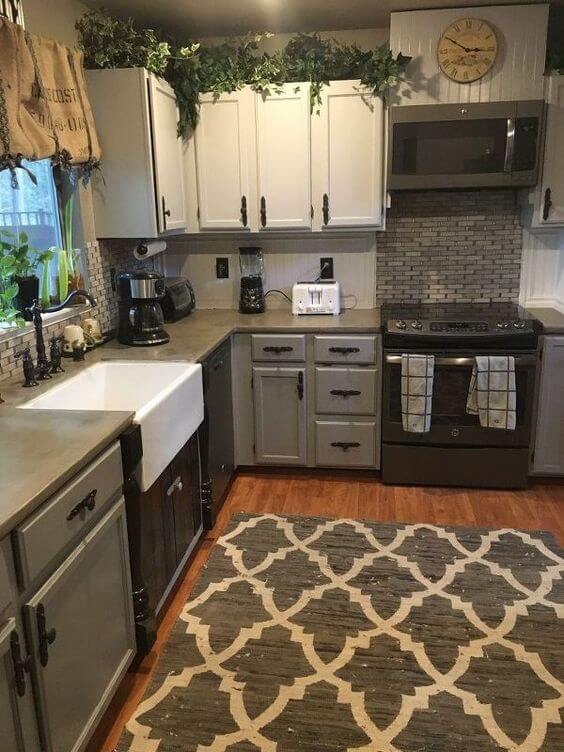 U-shaped small kitchen design featuring gray cabinetry, a farmhouse sink, mosaic tile backsplash, and efficient appliance layout.