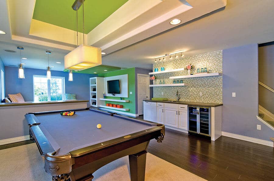 Game room with a regulation-sized pool table, navy felt surface, dark wood frame, and modern decor. Includes kitchenette and plush seating.