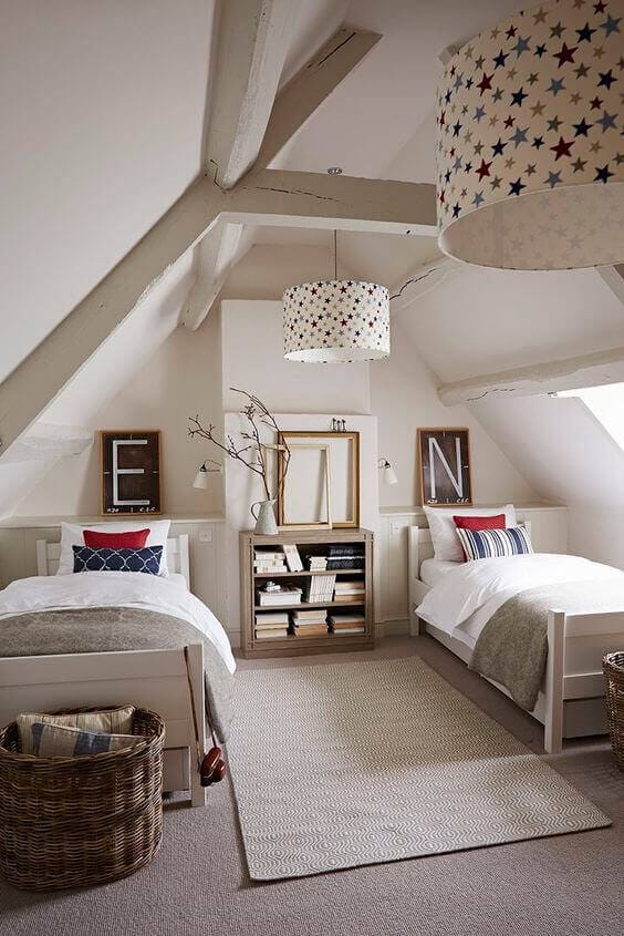 Children's bedroom with two twin beds, angled ceilings, star-patterned lamps, and a cozy rug, perfect for small attic design ideas.