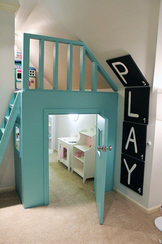 Vibrant turquoise playhouse with a loft, angled staircase, and 'PLAY' letters. Designed for imaginative fun with storage for toys.