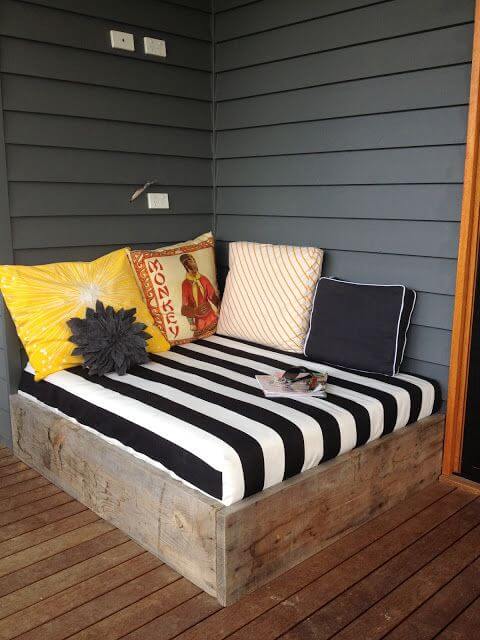 Cozy outdoor seating area with a 5-foot built-in bench, bold black and white striped cushions, and vibrant decorative pillows.