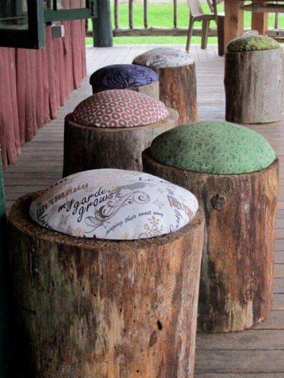 Cozy rustic seating made from natural tree stumps topped with colorful cushions, perfect for a budget-friendly backyard makeover.
