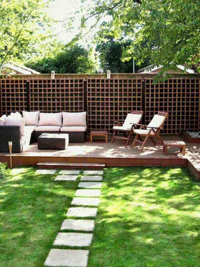 Outdoor lounge area with a wooden deck, beige sectional sofa, wooden lounge chairs, and a lattice fence, ideal for social gatherings.