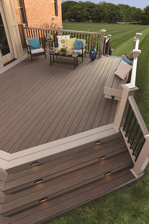 Spacious composite deck designed for outdoor relaxation, featuring a brown wood-like finish, black metal railing, and comfy seating.
