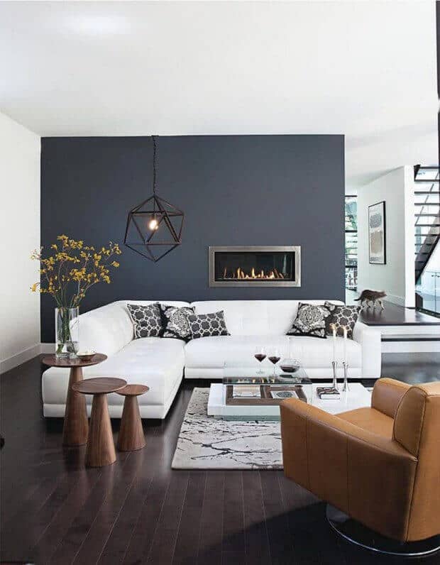 27 Contemporary Living Room Ideas for a Modern Haven Space 3 Spacious contemporary living room with a white sectional sofa, dark accent wall, built-in fireplace, and minimalist decor.