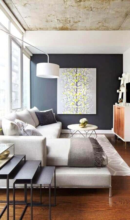 27 Contemporary Living Room Ideas for a Modern Haven Space 28 Spacious contemporary living room with a grey sectional sofa, dark accent wall, vibrant artwork, and natural light enhancing warm wood floors.