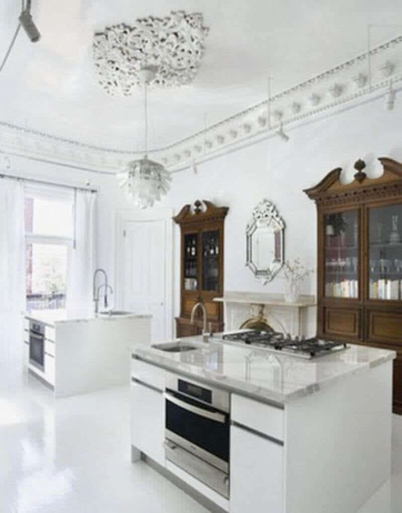 Modern kitchen with two large islands featuring white quartz countertops and integrated sinks, stainless steel appliances, and bright, airy decor.