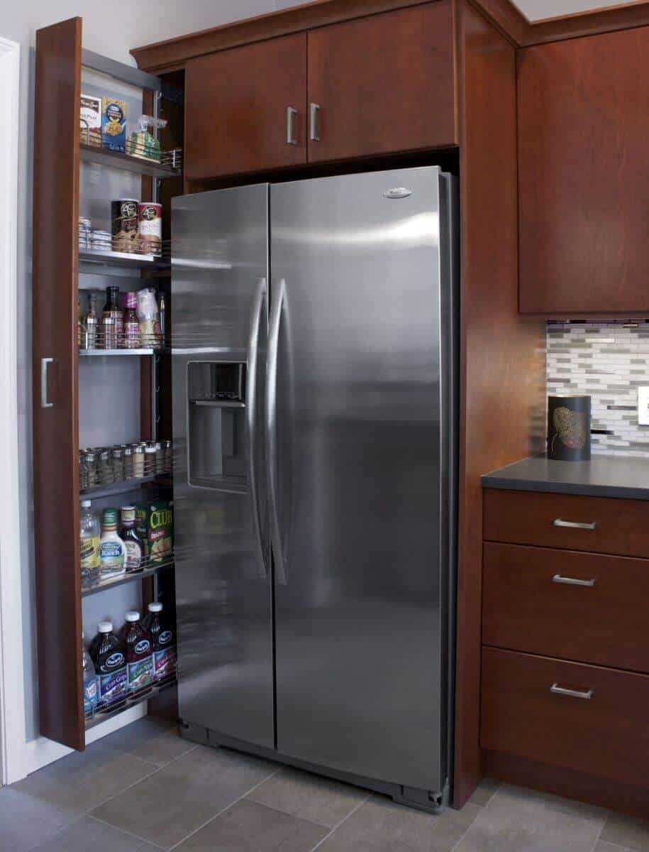Modern kitchen cabinetry in rich brown finish, featuring a tall pantry with adjustable shelves for efficient storage and organization.